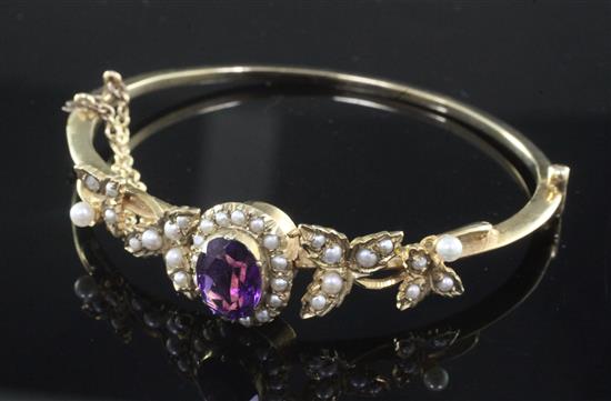 A Victorian style gold, amethyst and seed pearl cluster hinged bangle,